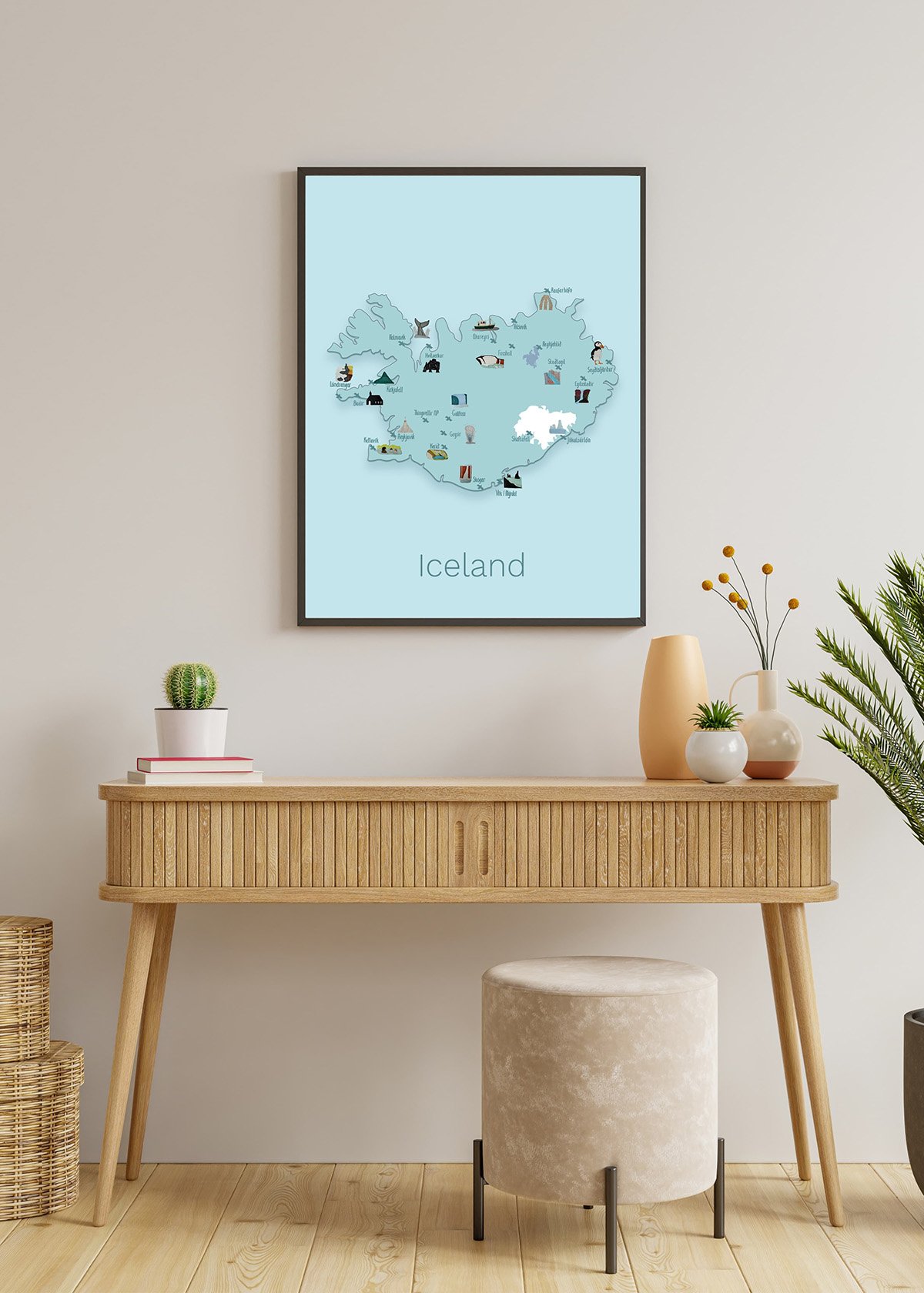 Alight brown dressoir is placed against a light brown and greyish wall . In a poster frame above the cabinet you can see a blue toned illustrated map of Iceland